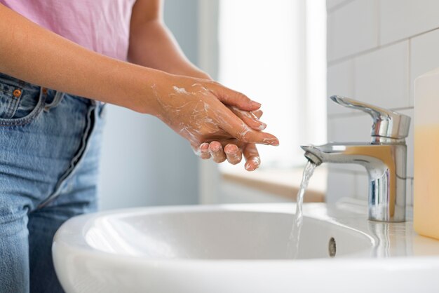 クローズアップの女性が彼女の手を洗う