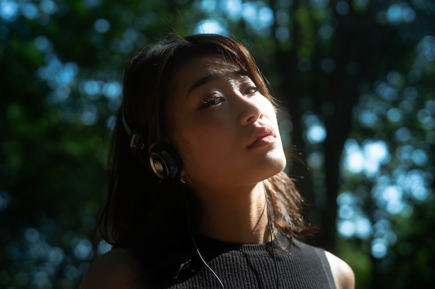 Free photo close up woman wearing headphones outside