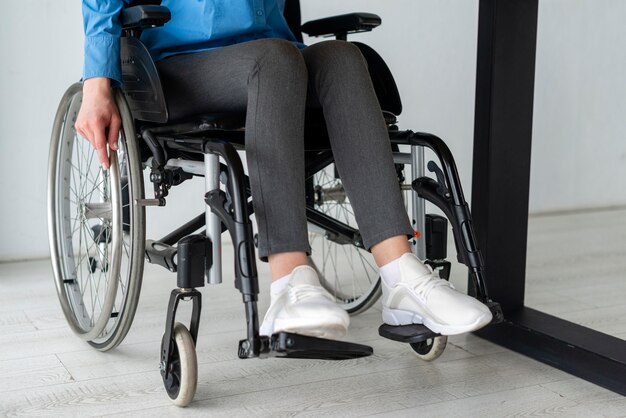Крупным планом женщина в инвалидной коляске в офисе