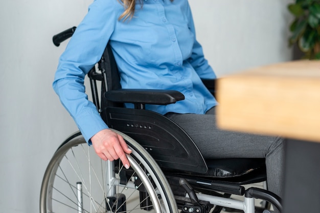 Close-up woman in wheelchair at the office