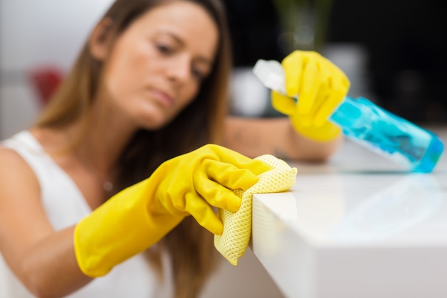 Close-up of woman wiping lacquer counter