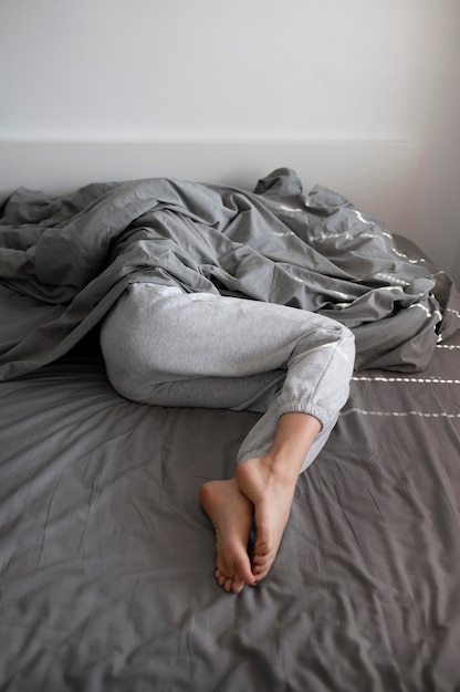 close up woman with anxiety under blanket