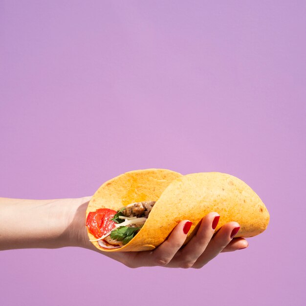 Close-up woman with burrito and purple background