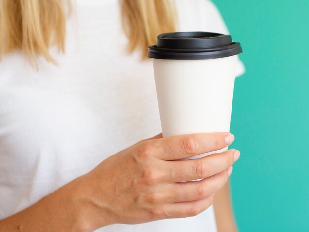 Close-up woman with coffee cup and green background