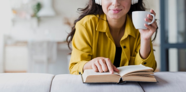 Foto gratuita donna del primo piano con la tazza e le cuffie