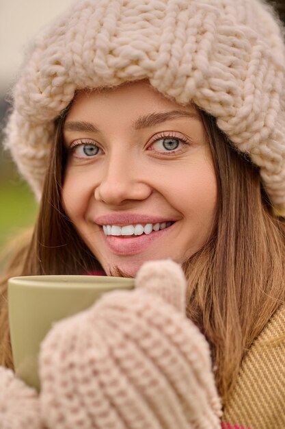 Close up woman with cup looking at camera