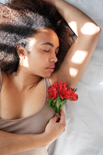 Primo piano sulla donna con fiori intorno all'ascella