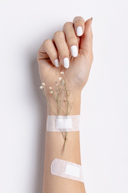 Free photo close-up woman with flowers and band-aids