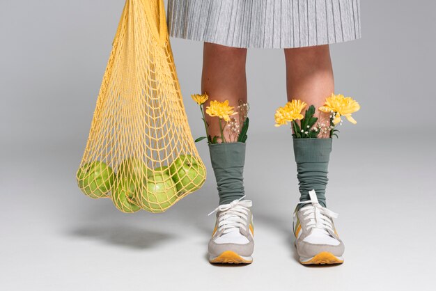 Close up woman with flowers on socks holding turtle bag