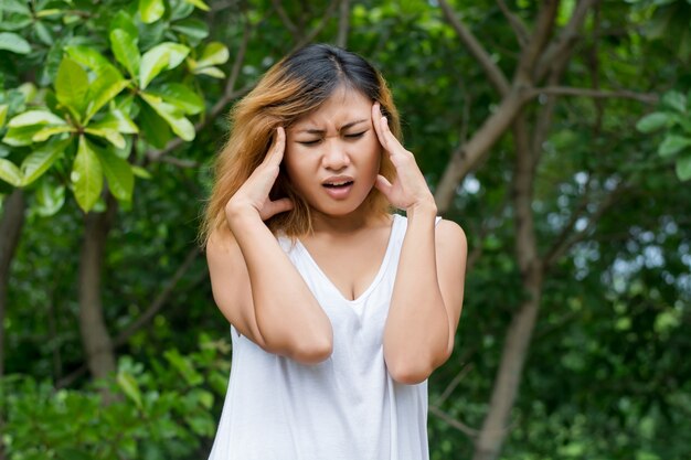 Close-up of woman with headache touching her forehead