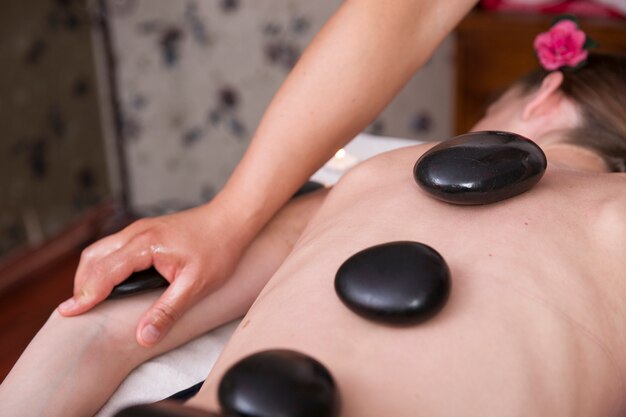 Close-up of woman with hot stones on her back