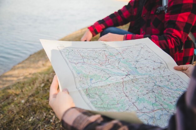 Close-up of woman with map by the lake