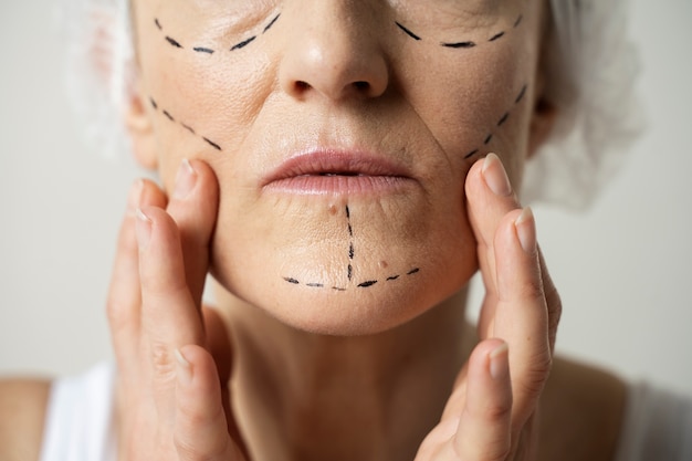 Бесплатное фото Крупный план женщины со следами маркера на лице