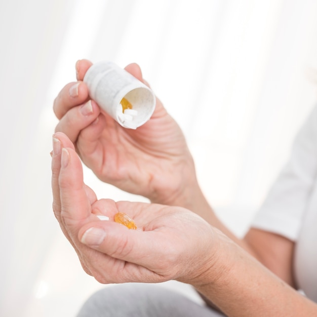 Close-up woman with medicine in the bedroom