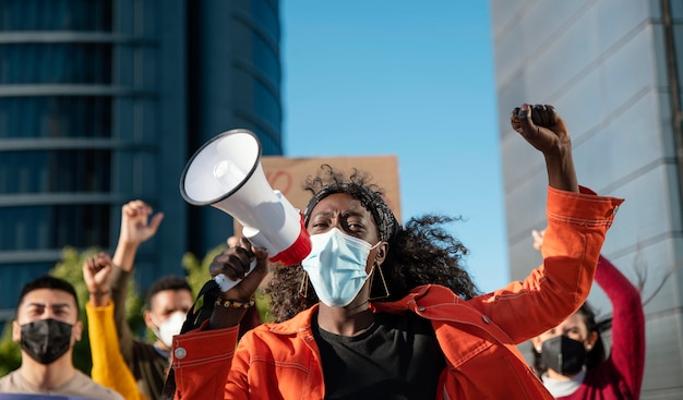 Close up woman with megaphone wearing mask