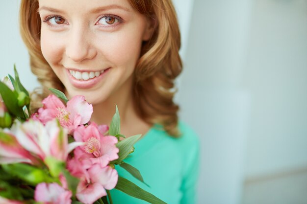 ピンクの花を持つ女性のクローズアップ