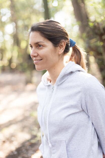 Close-up of a woman with ponytail and gray hooded sweatshirt