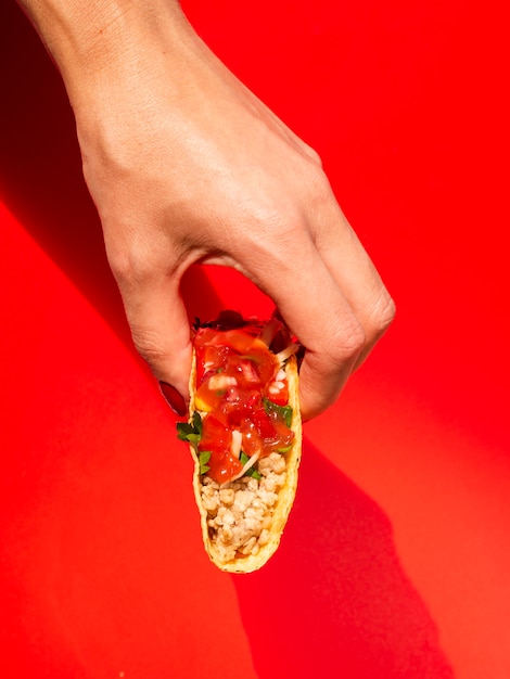 Foto gratuita donna del primo piano con taco e fondo rosso