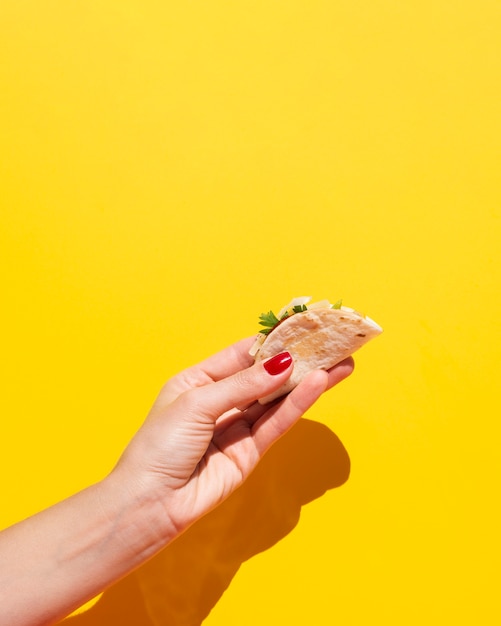 Foto gratuita donna del primo piano con taco e fondo giallo