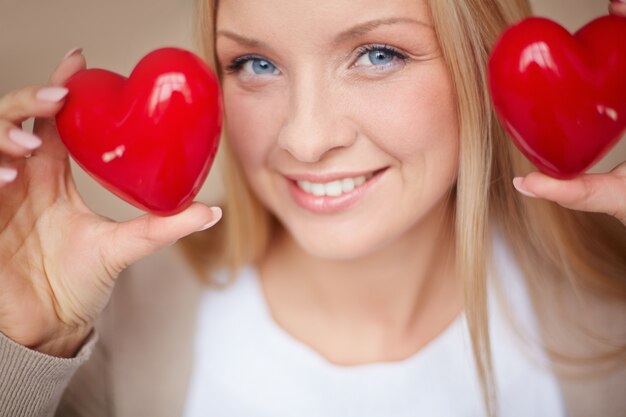 Крупным планом женщина с двумя красными сердцами