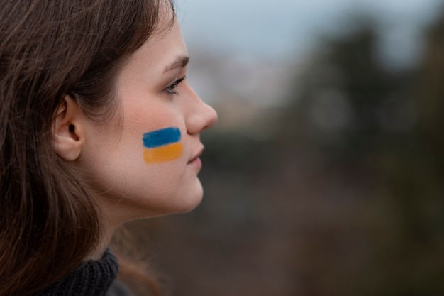 Close up woman with ukranian flag drawing