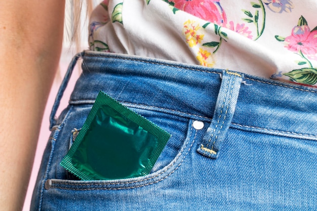 Close-up woman with wrapped condom in her pocket