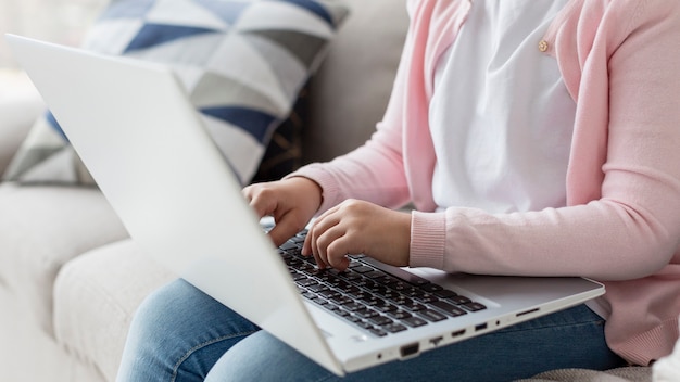 Close-up woman working on laptop from home