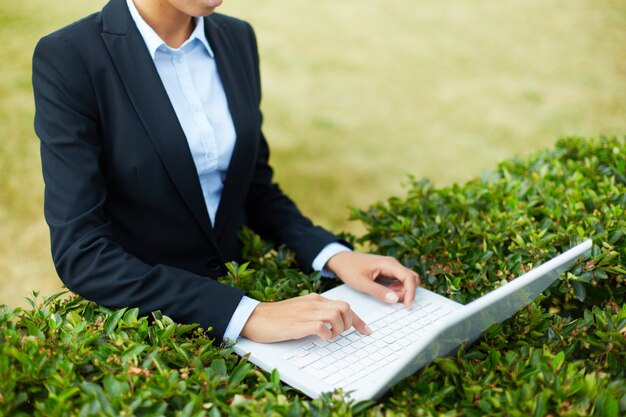 Close-up of woman working with laptop outdoor