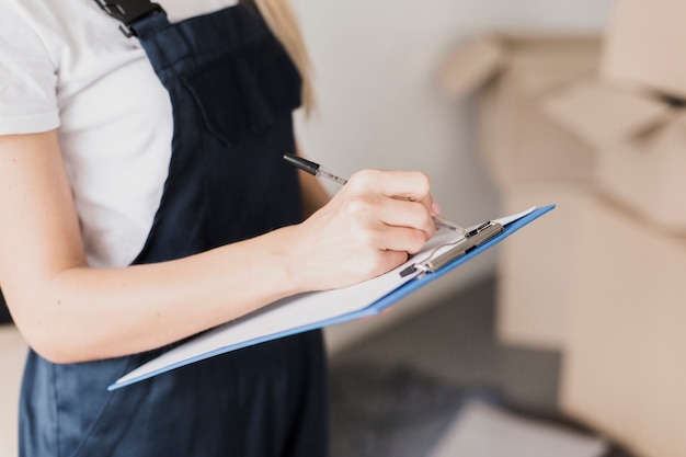 Free photo close-up woman writing on clipboard