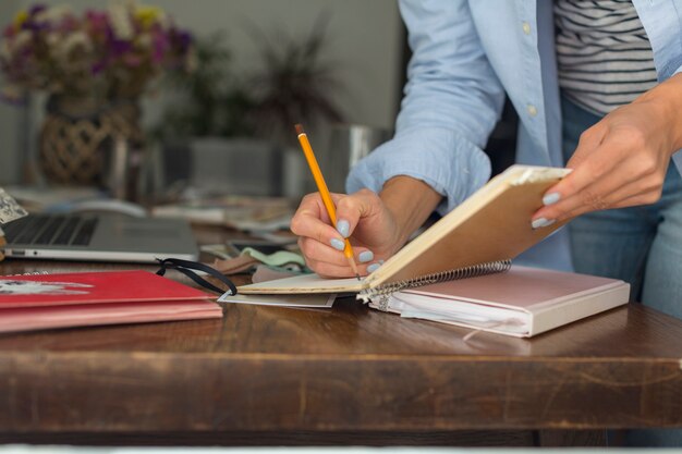 Close-up of woman writing on notebook