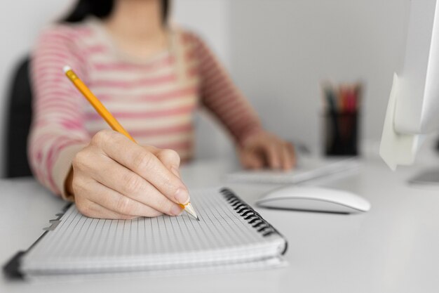 Close up woman writing on notebook