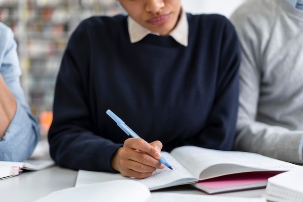 ノートに書いている女性をクローズアップ