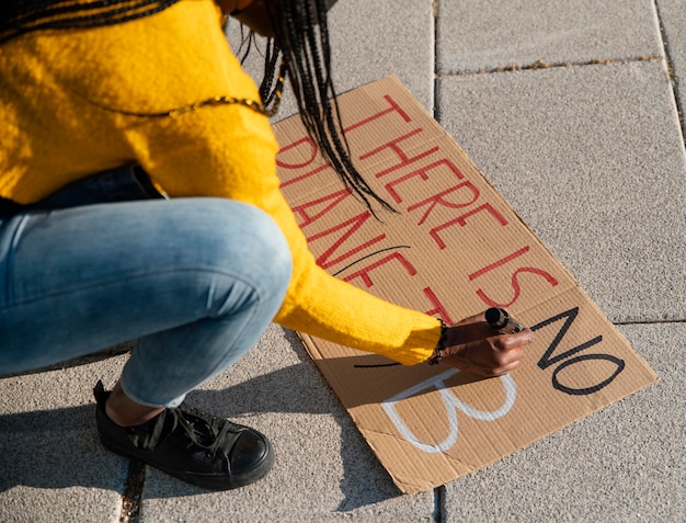 Foto gratuita chiuda sul cartello di scrittura della donna