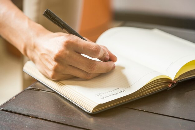 Close-up woman writing statistics in notebook