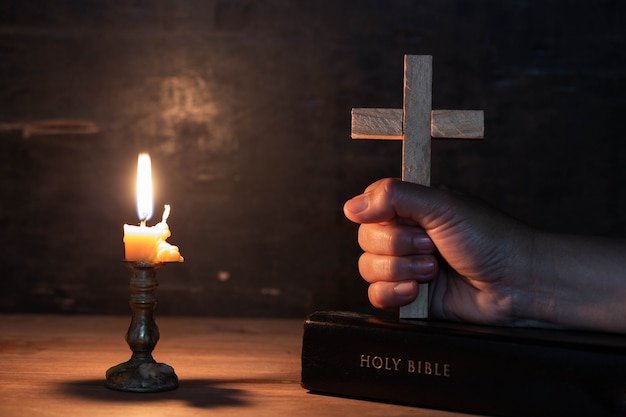 close up women hands holding wooden cross