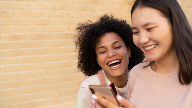 Free photo close up women looking at smartphone