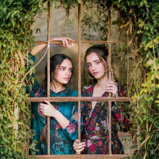 Close-up women looking through bars