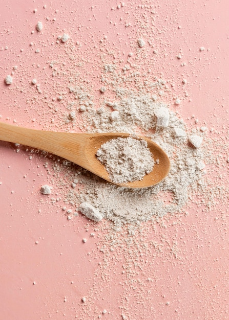 Close up of wooden spoon with clay powder mixture