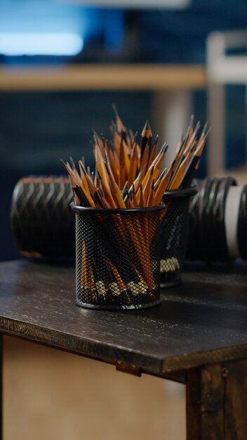 Закройте деревянный стол с красочными карандашами для художника