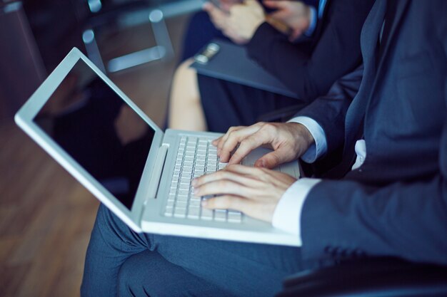 Close-up of worker hands typing on laptop