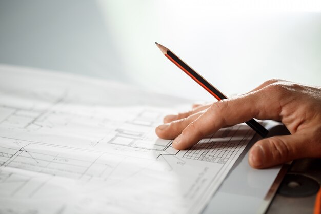 Close up of worker's hand on drawing.