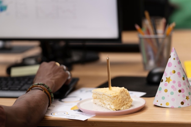 Close up worker with cake and party hat