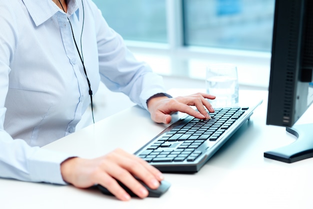 Close-up of worker working with mouse and keyboard