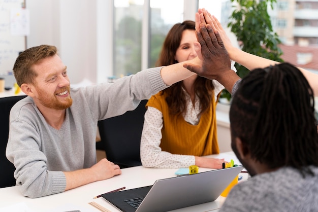 Foto gratuita chiudi i lavoratori batti il cinque