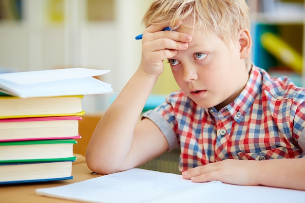 Close-up of worried schoolboy in class