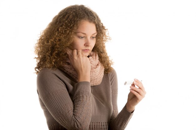 Close-up of worried woman with a thermometer