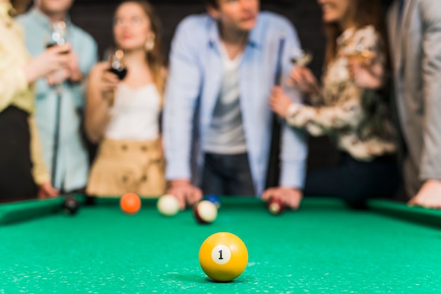Close-up of yellow billiard ball with one number on snooker table