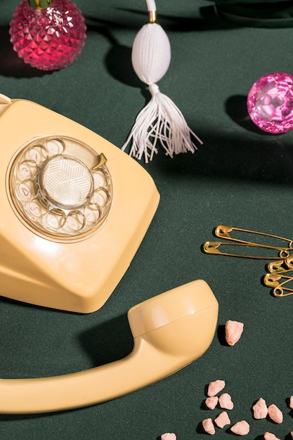 Close up yellow telephone next to girly items