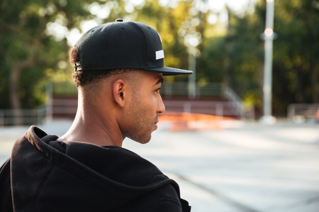 Close up of a young african man in cap looking away