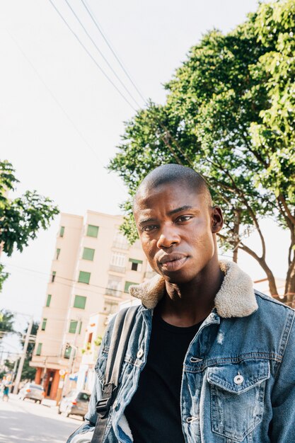 Close-up of a young african man standing on road looking at camera